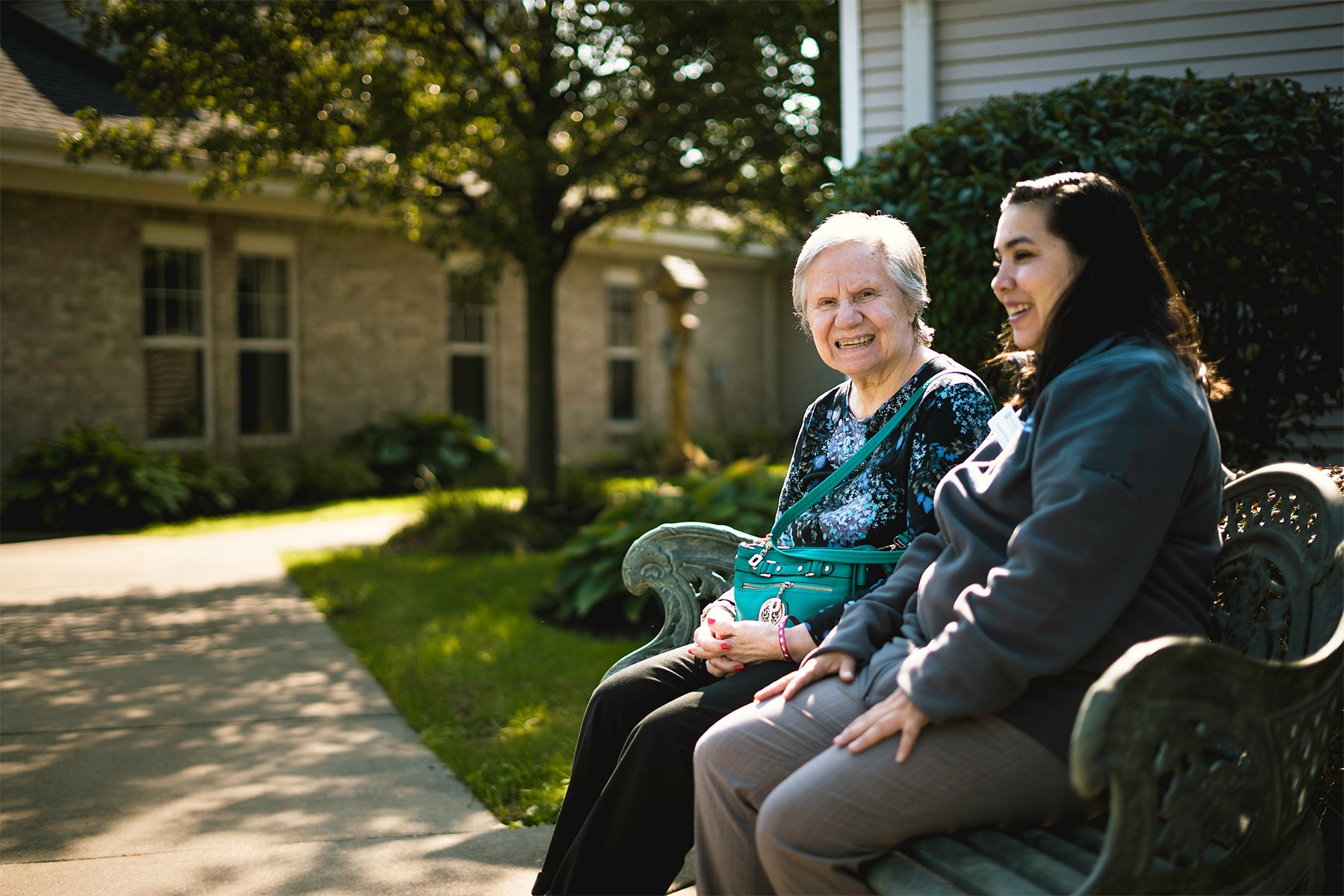 assisted living resident sitting outside with loved one