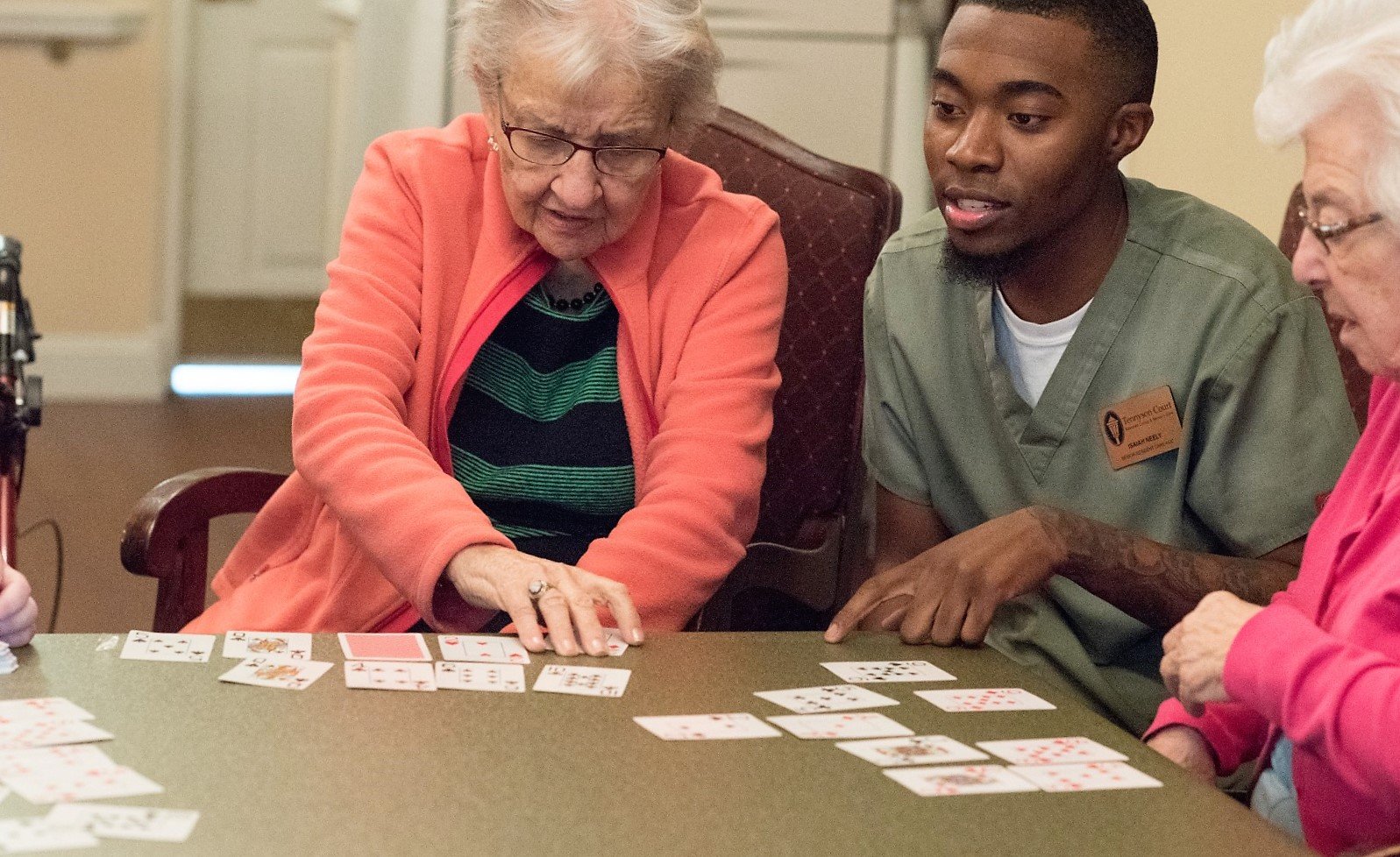 two respite stay residents playing a game with nurse staff member