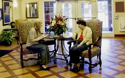 elderly residents sitting at table in assisted living facility