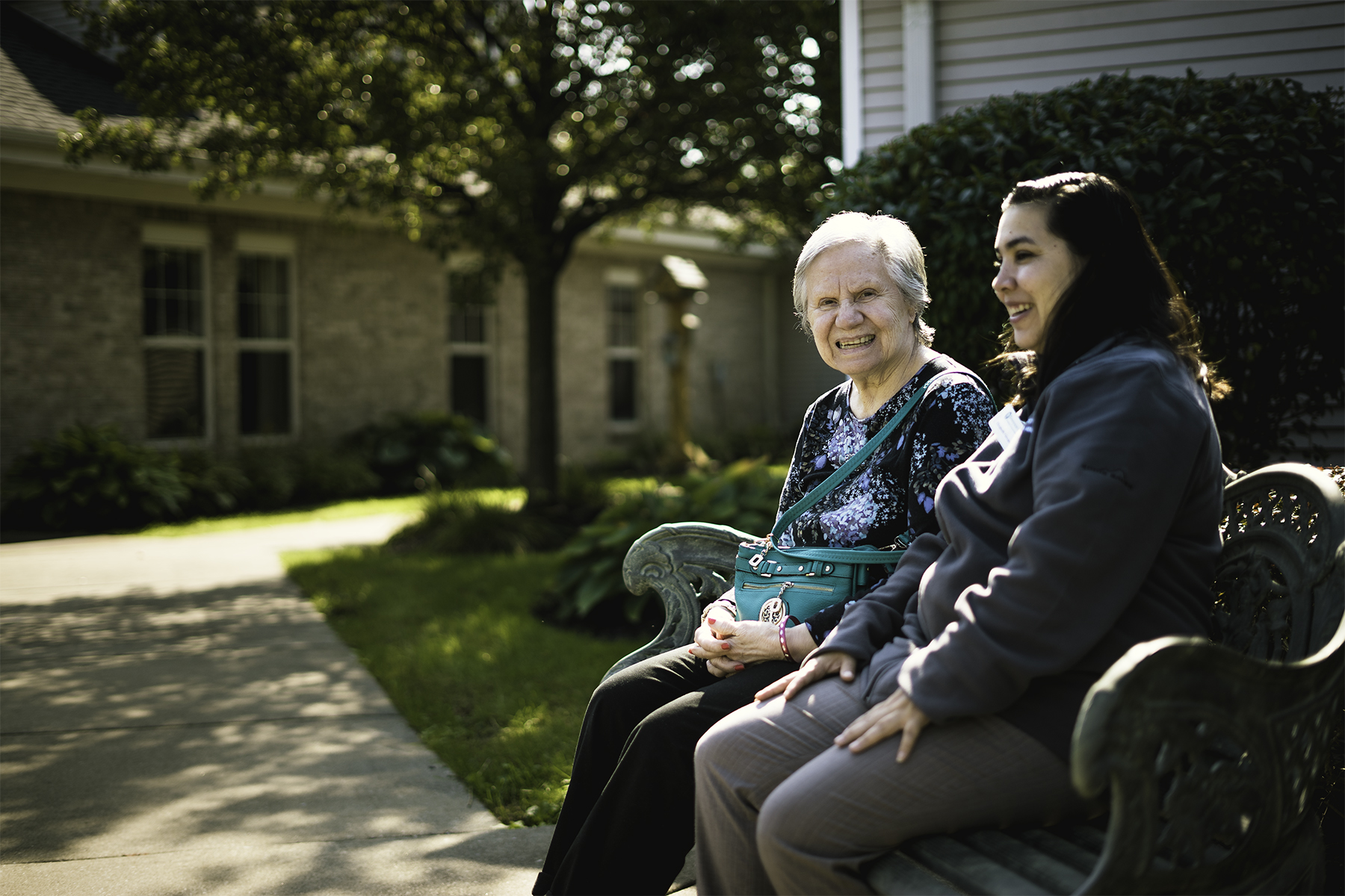 assisted living resident sitting outside with loved one