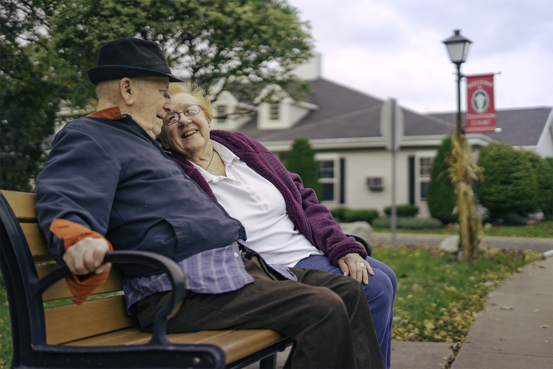 Elderly couple sitting on a bench in a respite care community