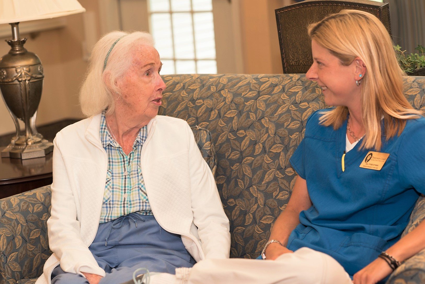senior care resident sitting with care taker
