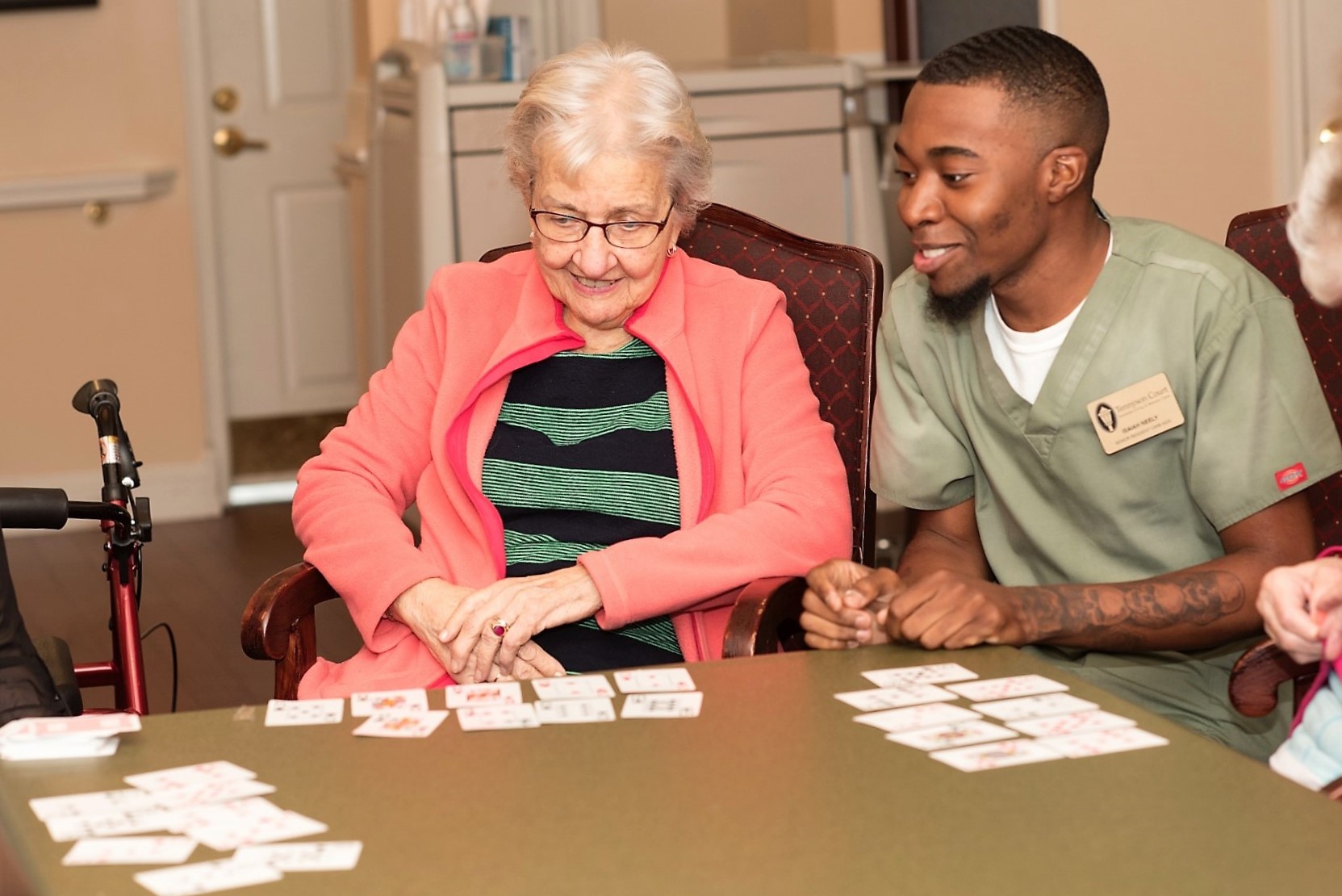 memory care resident playing a card game with a care proivder